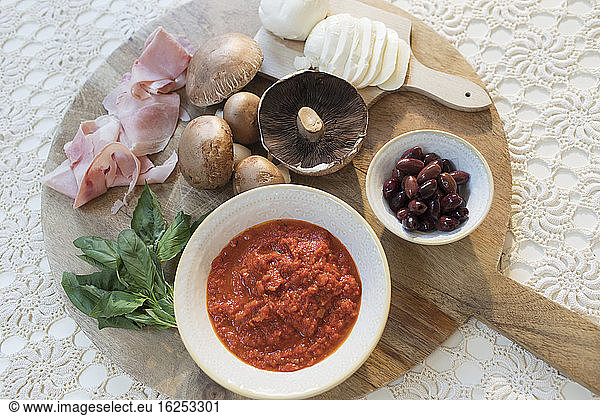 Overhead view pizza ingredients on cutting board