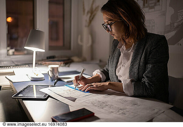 Overworked architect creating draft in dark office