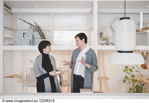Owner talking with female customer in fashion studio