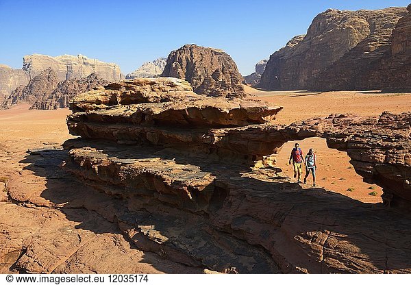 Pärchen beim Wandern am Felsenbogen  Al Borg Alsagheer  Wadi Rum  Jordanien  Asien