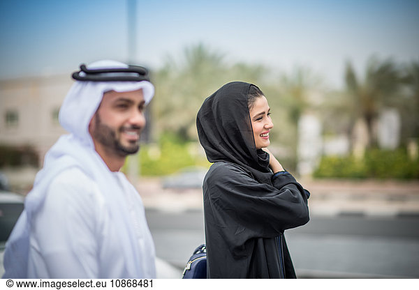 Paar aus dem Nahen Osten in traditioneller Kleidung auf der Straße  Dubai  Vereinigte Arabische Emirate