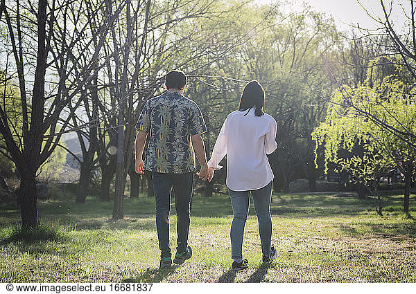 Paar geht Hand in Hand im Park spazieren