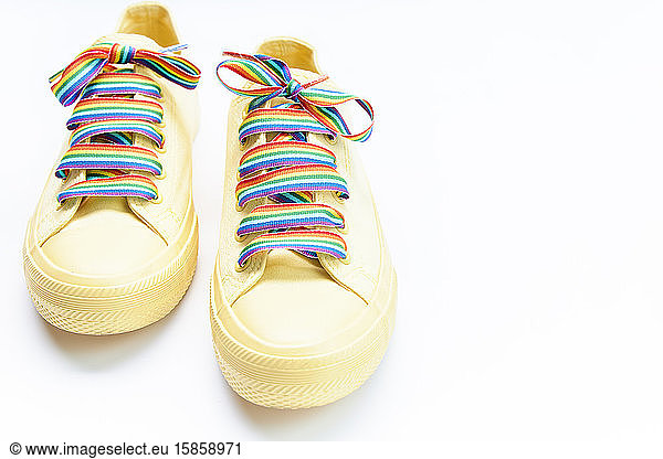 Paar gelbe Schuhe mit RegenbogenschnürsenkelnPaar gelbe Schuhe mit Regenbogen