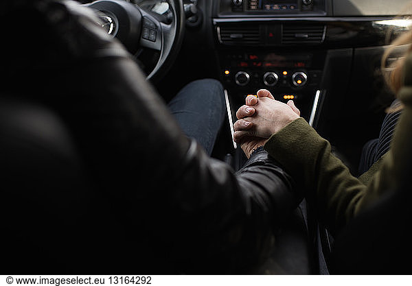 Paar Hände haltend im Fahrzeug