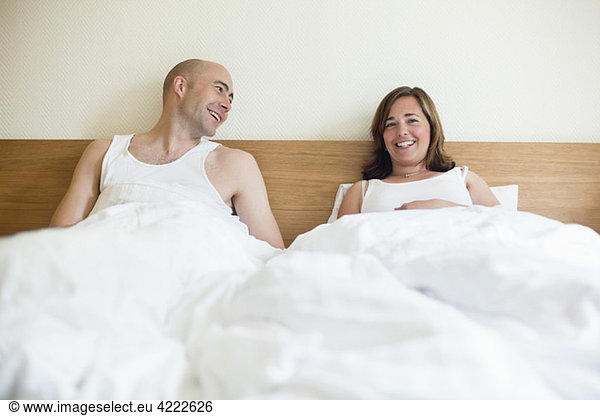 Paar im Bett sitzend