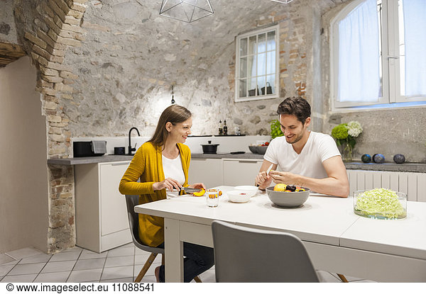 Paar in der Küche bei der Zubereitung von Obstsalat