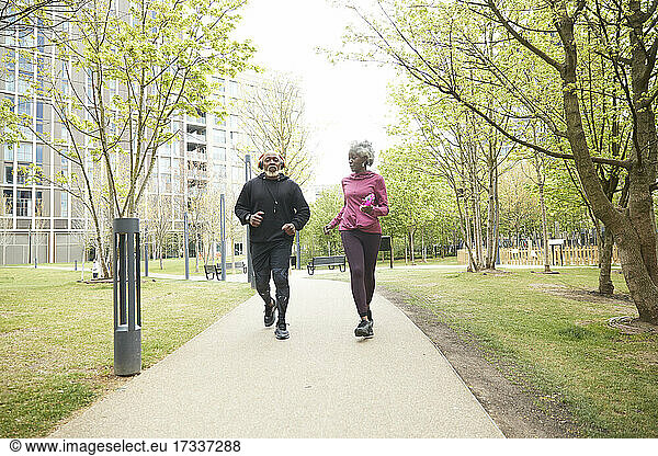 Paar joggt in Sportkleidung in einem öffentlichen Park