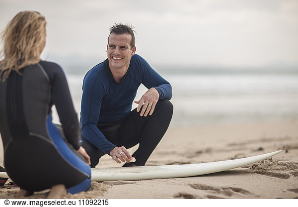 Paar mit Surfbrett am Strand