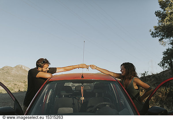Paar tauscht Autoschlüssel auf einer Autofahrt