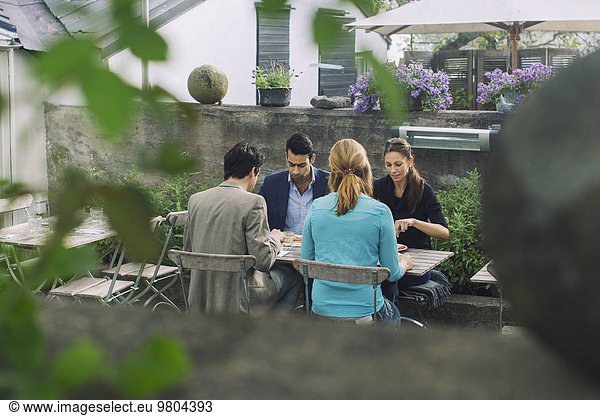 Paare beim Mittagessen im Outdoor-Café