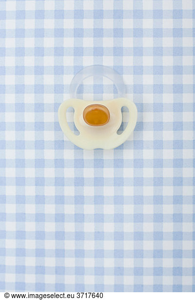 Pacifier on blue checker pattern
