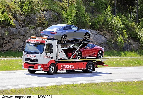 Paimio  Finland - June 1  2018: Volvo flatbed tow truck of Hinaus Sjoberg transports two new cars on motorway in the summer in South of Finland.