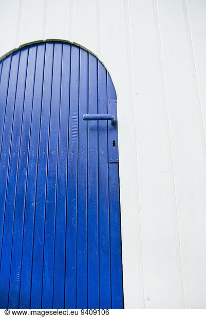 Painted blue wooden garden door white wall