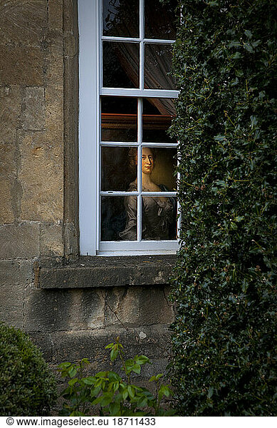 Paintings peer out through the window of a Fine Art Gallery in Broadway  England.