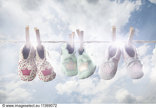 Pair of baby shoes hanging on clothes line