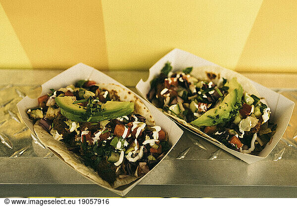 Pair of fresh tacos in take away boxes on concession stand