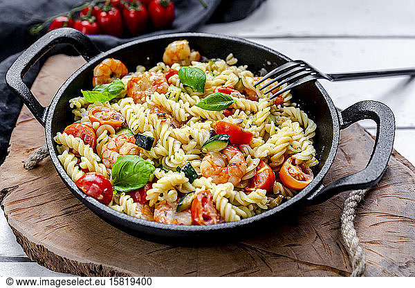 Pan of ready-to-eat pasta with tomatoes  shrimps  zucchini and basil