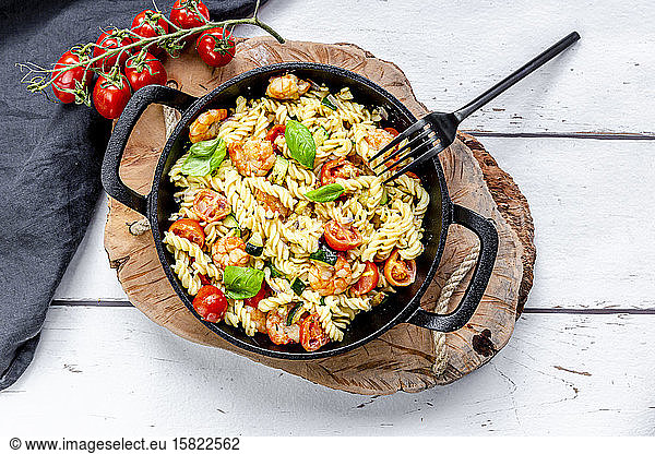 Pan of ready-to-eat pasta with tomatoes  shrimps  zucchini and basil