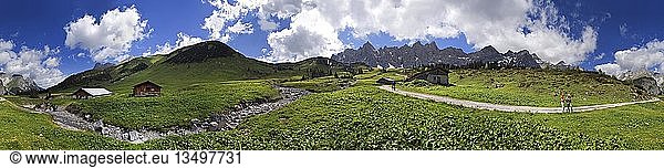 Panorama at the Ladizalm alipine pasture with Lalidererwaende Cliffs  hikers  meadows and clouds in the Karwendel Range  Tyrol  Austria  Europe