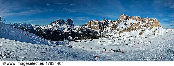 Panorama of a ski resort piste with people skiing in Dolomites in Italy. Ski area Belvedere. Canazei  Italy  Europe