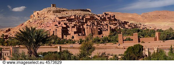 Panorama of Ait Benhaddou and blue berbers crossing Wadi Mellah near Ouarzazate Morocco