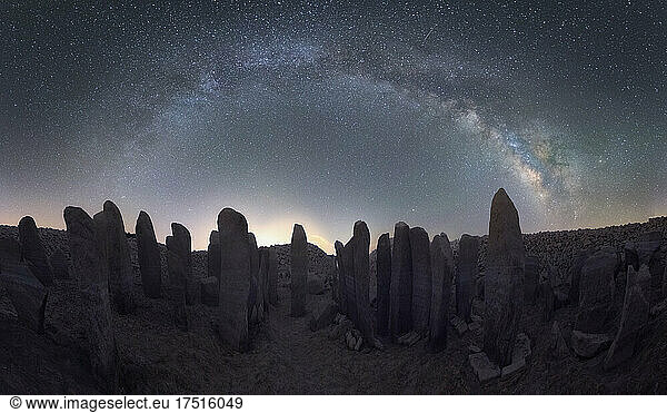Panorama of Megalithic monuments under stars sky with Milky Way arch