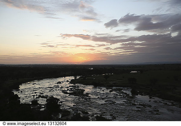 Panoramablick auf den Fluss inmitten der Landschaft im Serengeti-Nationalpark bei Sonnenuntergang