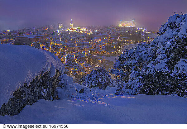 Panoramablick bei Einbruch der Dunkelheit auf den historischen Filomena-Schneefall in Toledo