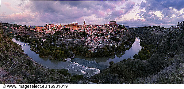 Panoramablick mit Fluss auf die Altstadt von Toledo bei Sonnenaufgang bunt