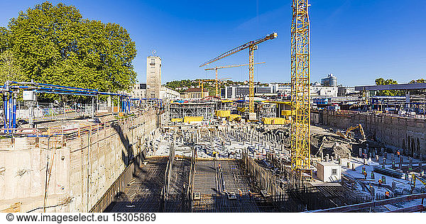 Panoramic view of cranes at construction site against blue sky