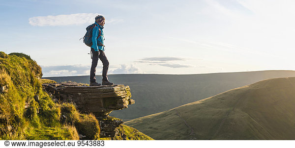 Panoramic view of hiker overlooking remote landscape