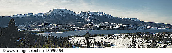 Panoramic view of river against mountains during winter
