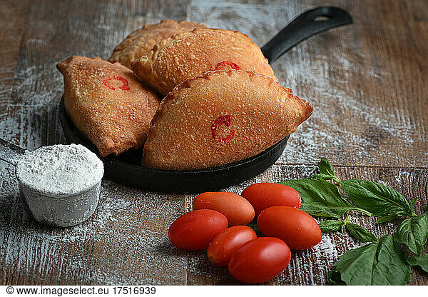 Panzerotti over a black pan in a wood table
