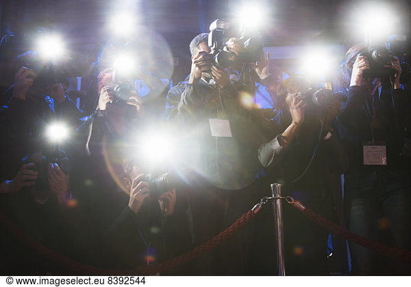 Paparazzi using flash photography at red carpet event