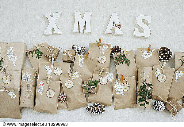 Paper bags with pine cones and Christmas decoration kept on carpet