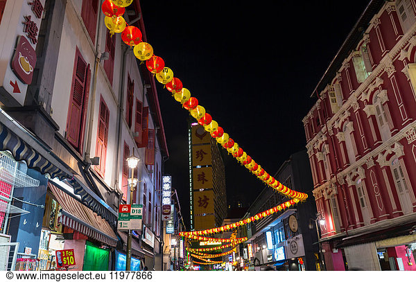Paper lanterns and shopfronts in chinatown street at night  Singapore  South East Asia