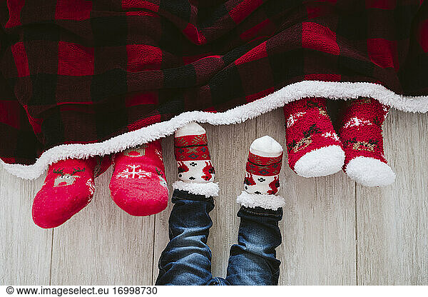 Parents and baby boy wearing Christmas socks at home during Christmas