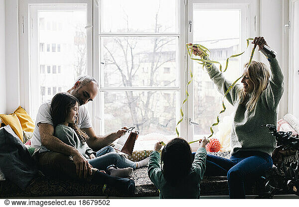 Parents and children decorating for birthday party celebration at home