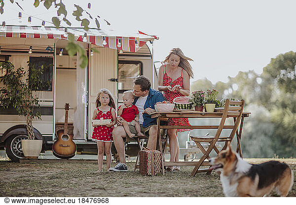 Parents and children prepating picnic camper van