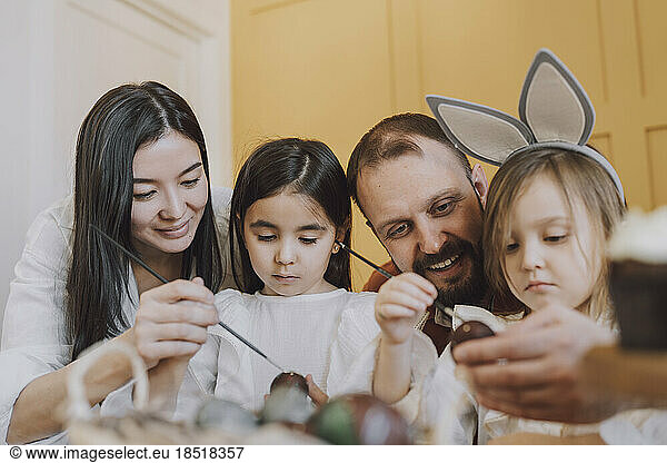 Parents and daughters decorating Easter eggs at home