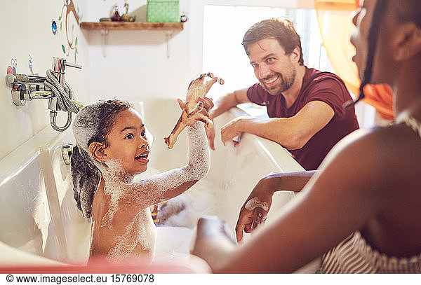 Parents giving daughter bubble bath