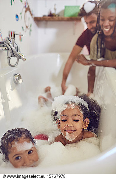 Parents giving daughters bubble bath