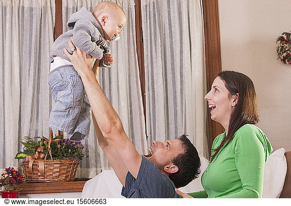 Parents holding up their baby son to play
