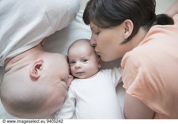 Parents kissing their baby boy  close up