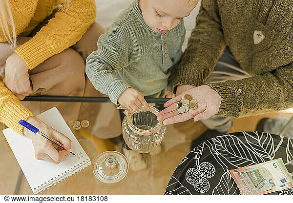 Parents with boy counting coins at home