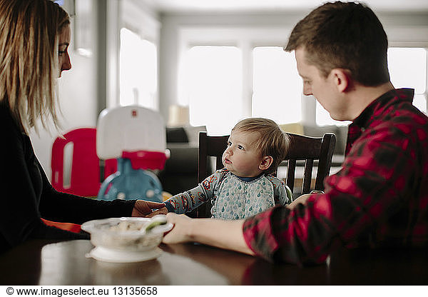 Parents with food on table looking at son