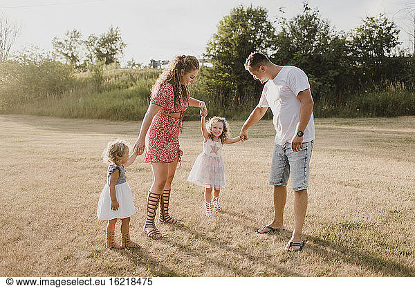 Parents with two daughters standing on a meadow