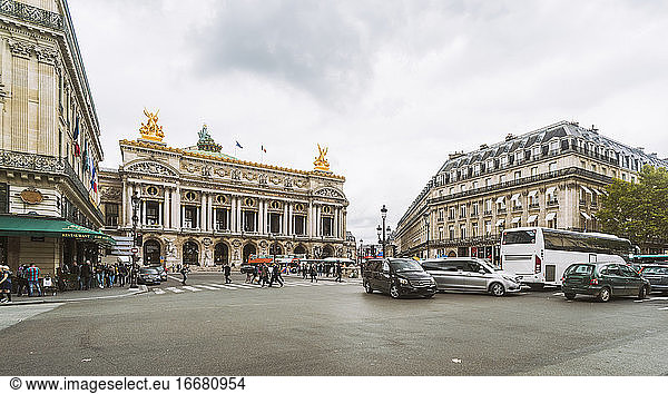Paris Opera house with heavy traffic on the square in front of it