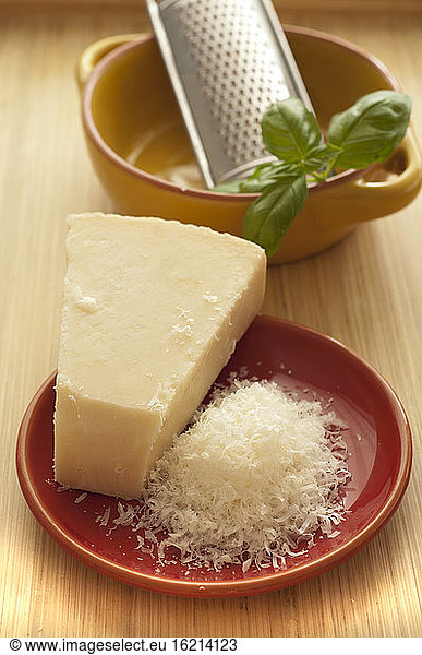 Parmesan cheese with basil on wooden table  close up