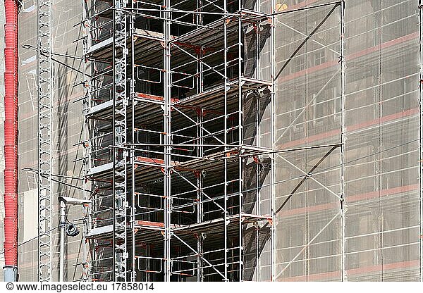 Part of construction site with scaffolding on multistory building facade during renovation